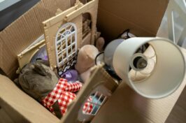 cardboard box filled with toys and a lamp shade